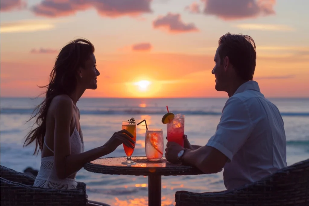 Pareja disfrutando una cena romántica al atardecer, con velas y vista al mar, en su viaje de luna de miel.