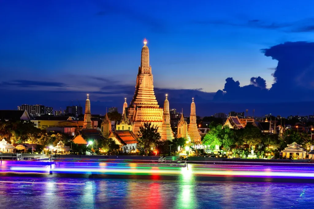 bangkok-thailandia-transamerica Templo Wat Arun en Bangkok, Tailandia, iluminado al anochecer con reflejos en el río. Viajes exóticos con Transamerica Viajes.